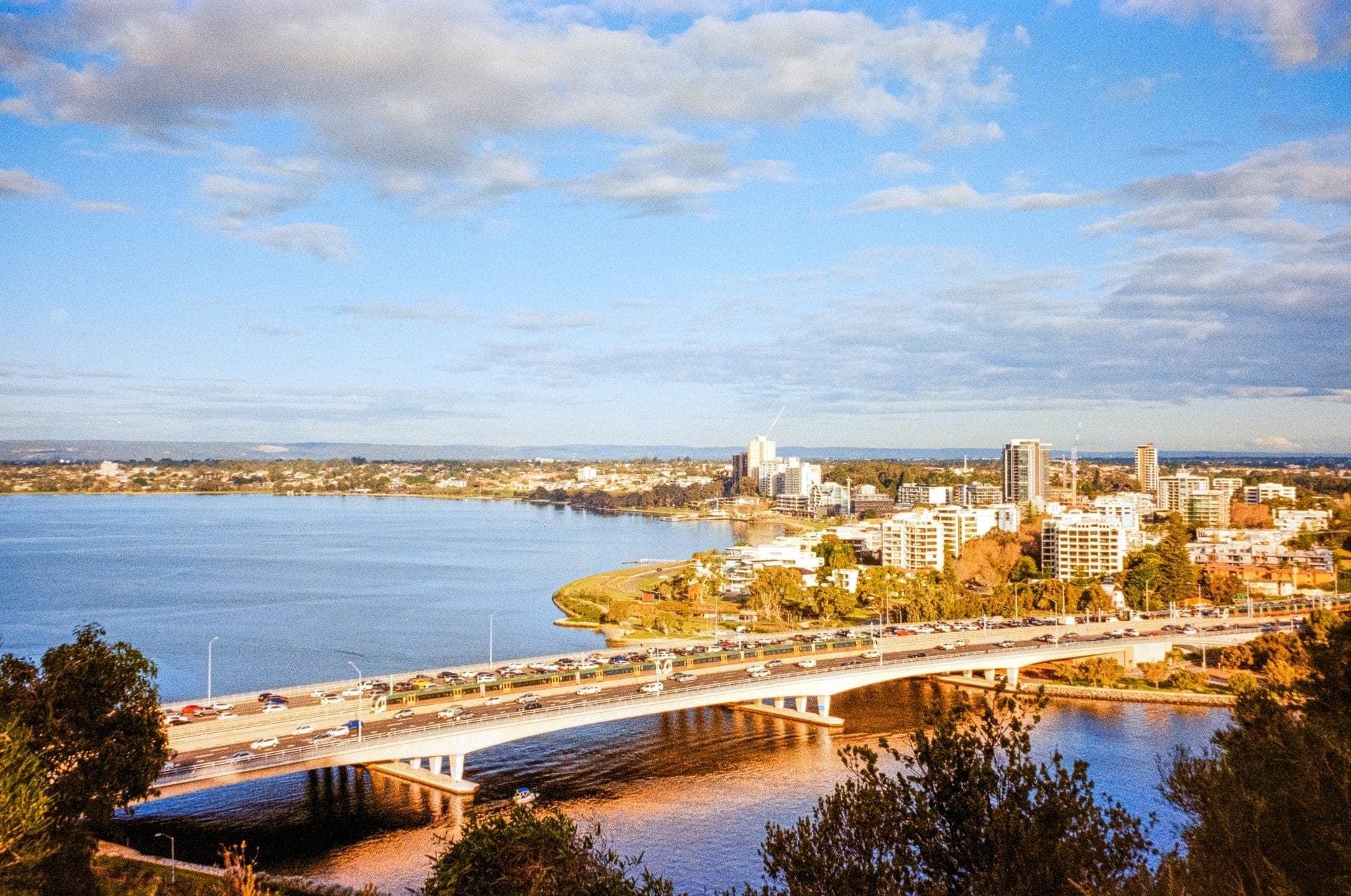 Aerial view of the Perth cityscape and the Swan River, the corridor maxi cabs cross between the CBD and Perth Airport. Maxi Cab Perth runs fixed-fare maxi taxi pickups in Ellenbrook.